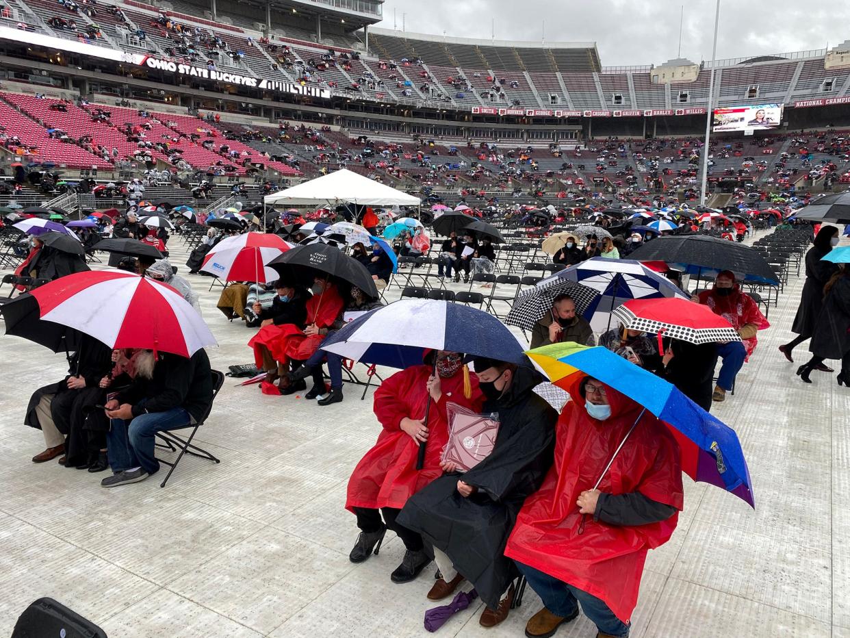 Ohio State graduates and their guests sit in the rain during the early graduation ceremony on Sunday, May 9, 2021. The university announced a plan Friday that would allow its students to graduate without debt within 10 years.