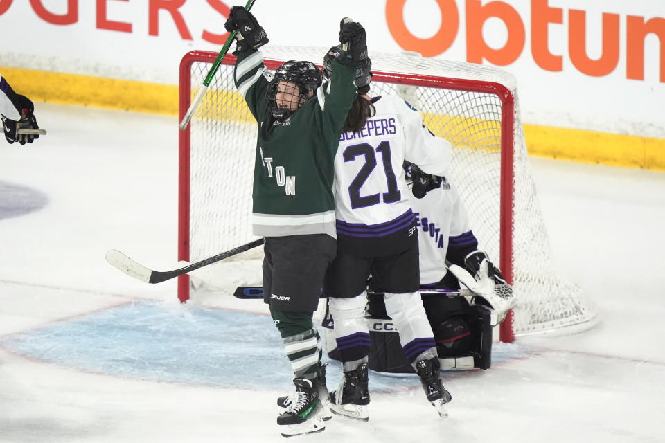 Boston forward Amanda Pelkey, left, celebrates in front of Minnesota forward Liz Schepers, center, after Boston scored during the second period in Game 1 of a PWHL hockey championship series, Sunday, May 19, 2024, in Lowell, Mass. (AP Photo/Steven Senne)