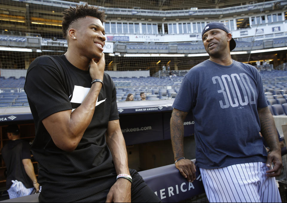 Milwaukee Bucks forward and 2019 NBA Most Valuable Player Giannis Antetokounmpo, left, talks to New York Yankees starting pitcher CC Sabathia before a baseball game between the Yankees and the Tampa Bay Rays, Monday, July 15, 2019, in New York. (AP Photo/Kathy Willens)