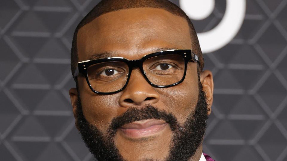 tyler perry smiling for a photo while wearing a bowtie and suit