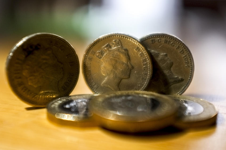 Picture of a composition of the old round coins and the new 12 sided pound coins, London