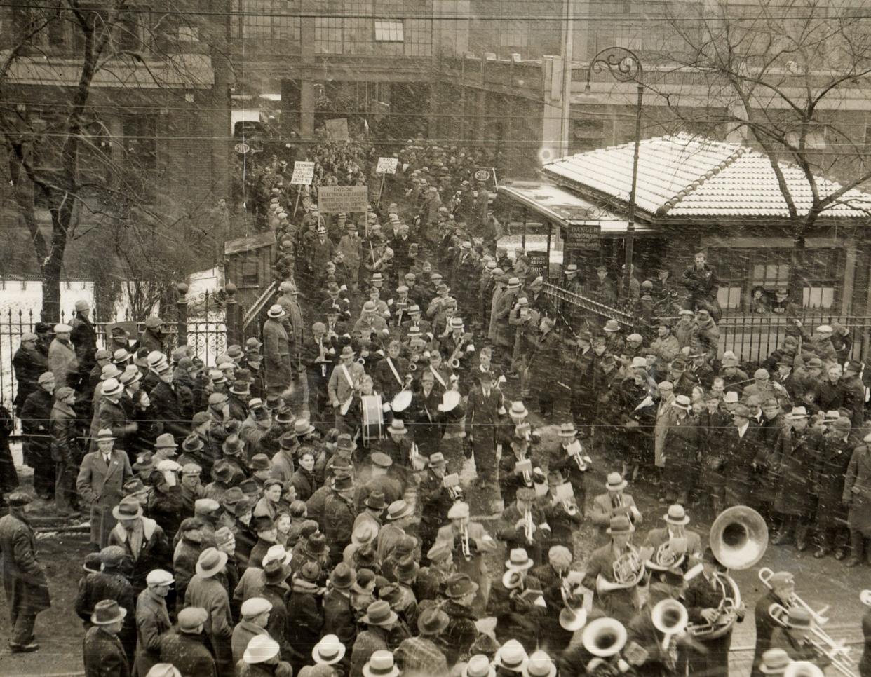 UAW workers parade out of the Dodge Main plant in Hamtramck behind the color guard and blaring brass band in March 1937, at the end of a long and bitter strike.