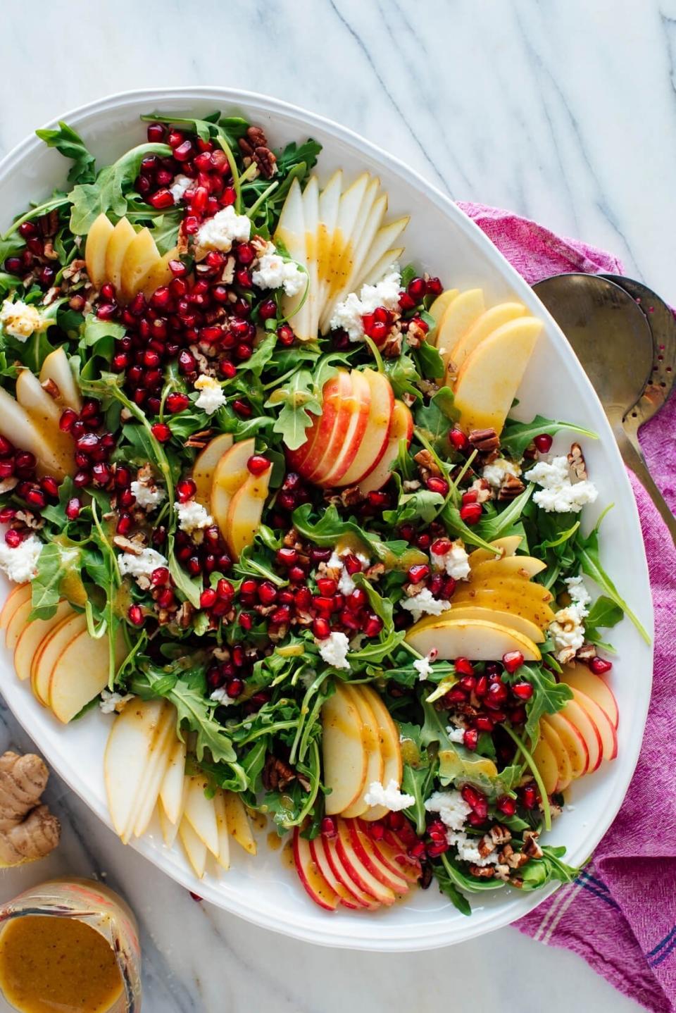 sliced pears, pomegranate seeds, pecans, and goat cheese atop a bed of arugula