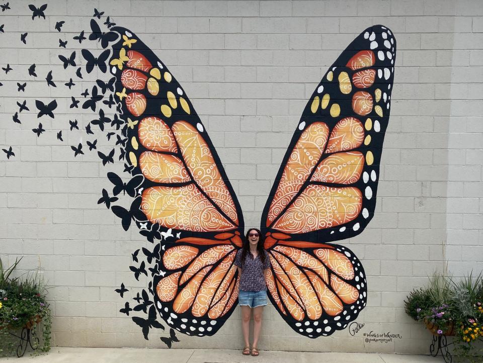 Insider reporter Talia Lakritz poses with a monarch butterfly mural in Sevierville, Tennessee