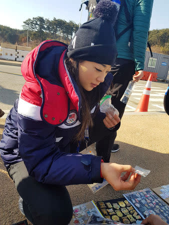 U.S. Olympic figure skater Mirai Nagasu looks at the Olympic pin collection of Bob Kalmuk, from California, outside the Gangneung Ice Arena during the Pyeongchang 2018 Winter Olympics, Gangneung, South Korea February 13, 2018. REUTERS/Philip O' Connor