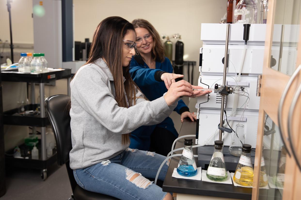 Student Barbara Miller (front) and Associate Professor Shannon Riha work in the instrument room at the University of Wisconsin-Stevens Point. The university will be conducting research to see if plants are effective phytoremediators for "forever chemicals."