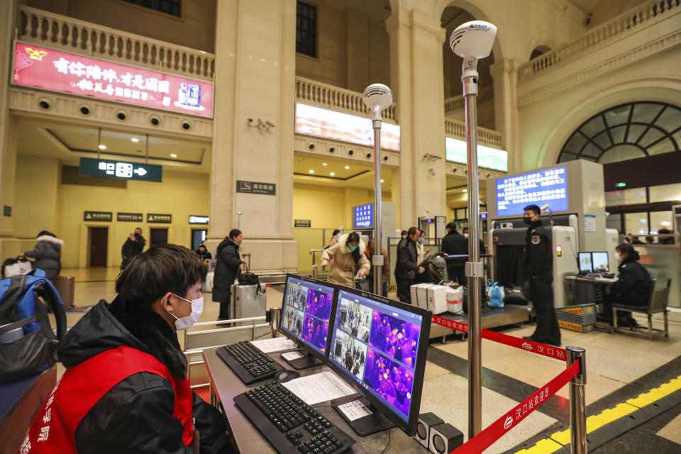 FILE - In this Jan. 21, 2020, file photo, a worker monitors display screens for infrared thermometers as they check travelers at Hankou Railway Station in Wuhan in southern China's Hubei province before authorities seals the city. For weeks after the first reports of a mysterious new virus in Wuhan, people poured out of the central Chinese city, cramming onto buses, trains and airplanes as the first wave of China's great Lunar New Year migration broke across the nation. Some carried with them a new virus that has claimed over 560 lives and sickened more than 28,000 people. (Chinatopix via AP, File)