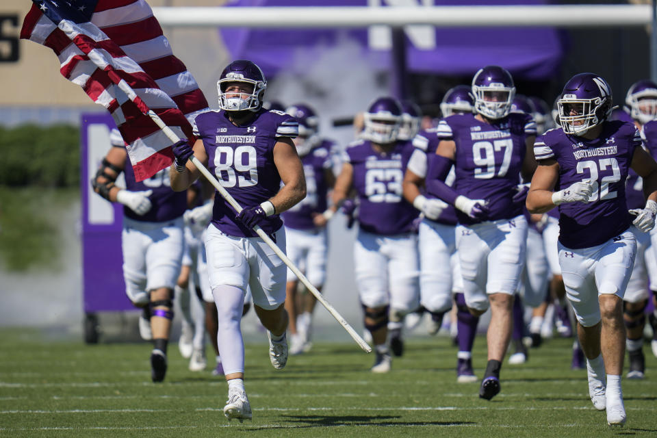 Northwestern tight end Charlie Mangieri carries an American flag as his team takes the field for an NCAA college football game against UTEP, Saturday, Sept. 9, 2023, in Evanston, Ill. (AP Photo/Erin Hooley)