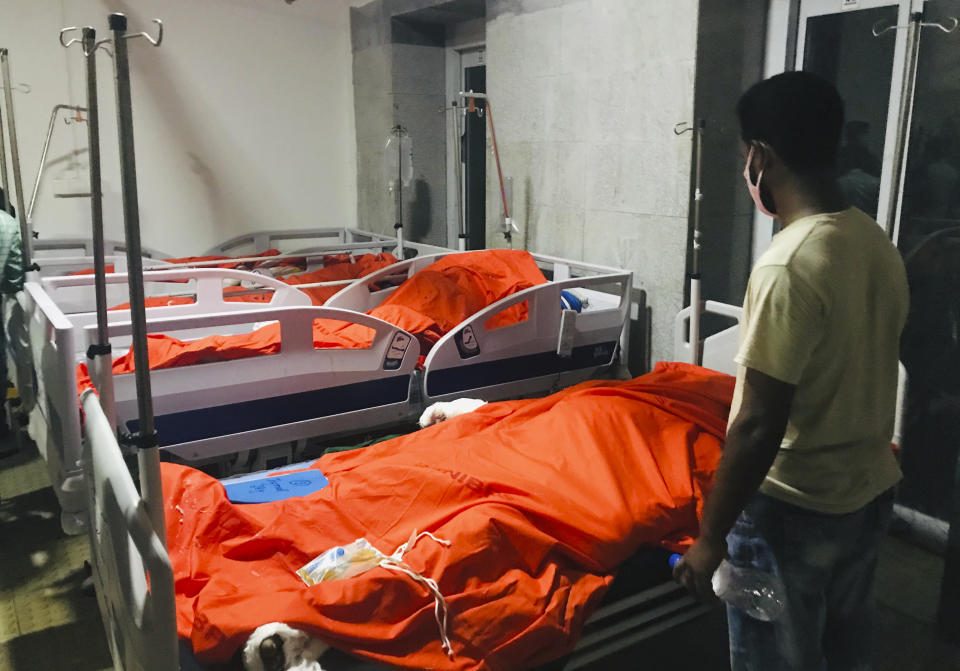 A man stands by the bodies of victims of a gas pipeline explosion at a hospital in Dhaka, Bangladesh, Saturday, Sept. 5, 2020. An underground gas pipeline near a mosque exploded during evening prayers outside the capital of Bangladesh, leaving at least 11 Muslim worshipers dead and dozens injured with critical burns, officials said Saturday. The blast occurred Friday night as people were finishing their prayers at Baitus Salat Jame Mosque at Narayanganj, local police chief Zayedul Alam said. (AP Photo/Al-emrun Garjon)