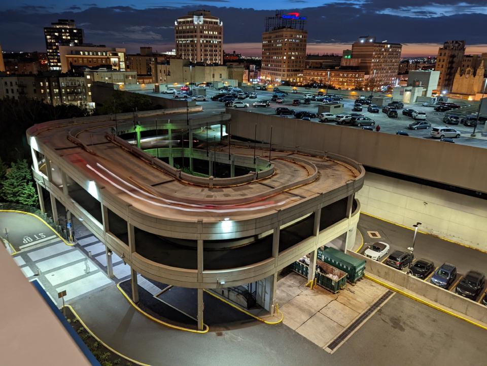 <p>A wider version of a Pixel 6 camera Motion mode Long Exposure sample showing a trail of lights going down a parking lot ramp.</p>
