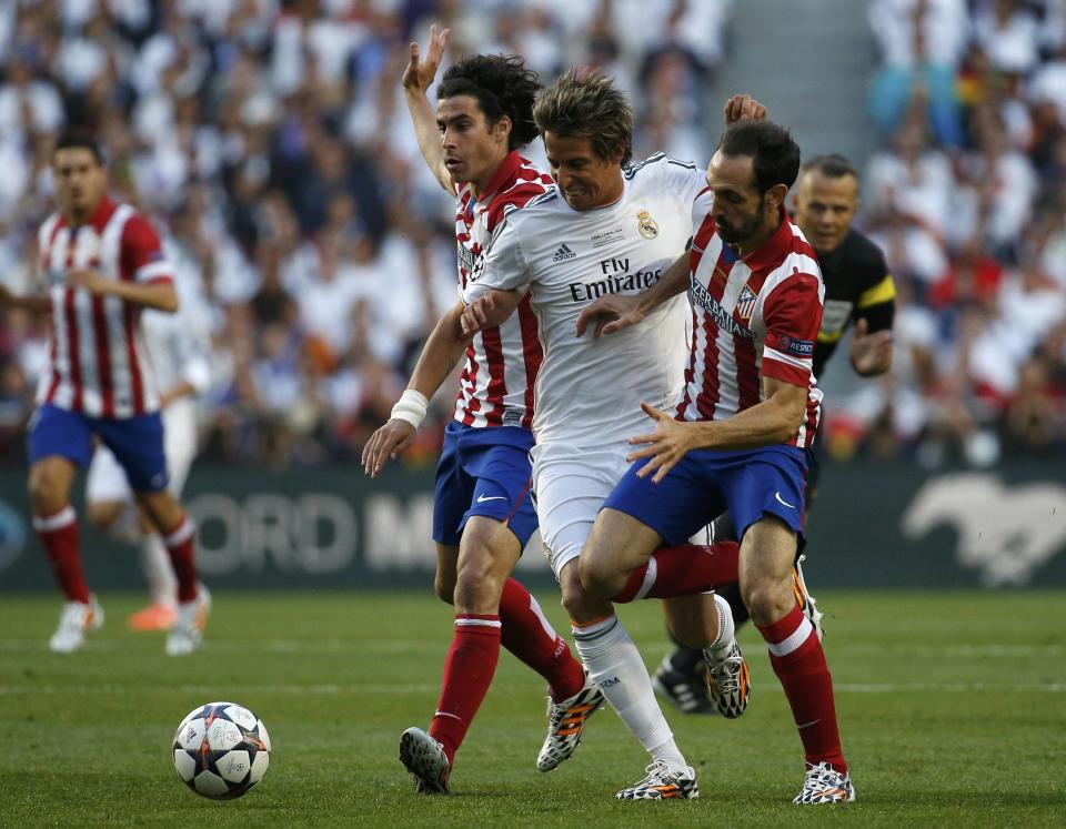 Atletico Madrid's Juanfran (R) challenges Real Madrid's Fabio Coentrao (C) during their Champions League final soccer match at the Luz Stadium in Lisbon May 24, 2014. REUTERS/Paul Hanna (PORTUGAL - Tags: SPORT SOCCER)