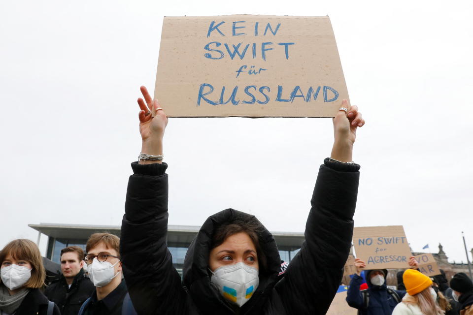 A protestor holds a sign that reads 