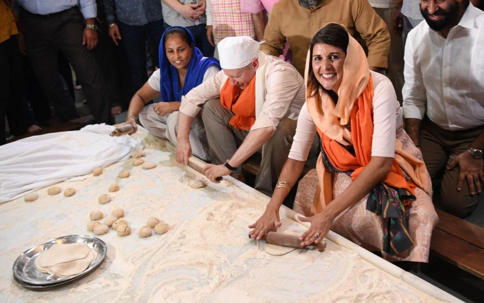 Haley makes bread in the kitchen of the Sis Ganj Gurudwara with US Ambassador to India Kenneth Juster, centre, in New Delhi, 2018 (AFP)