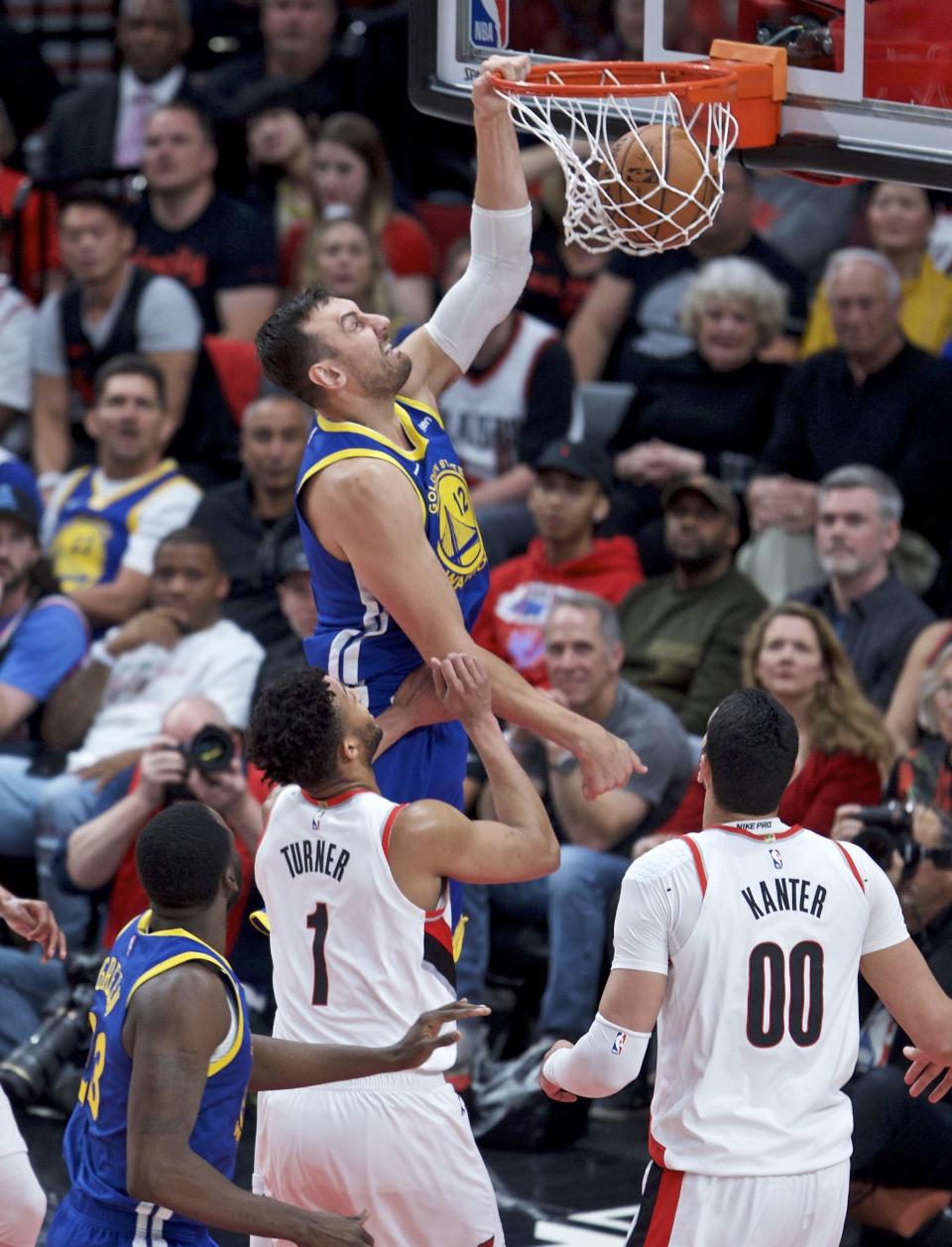 Golden State Warriors center Andrew Bogut, top, dunks over Portland Trail Blazers guard Evan Turner during the first half of Game 4 of the NBA basketball playoffs Western Conference finals Monday, May 20, 2019, in Portland, Ore. (AP Photo/Craig Mitchelldyer)
