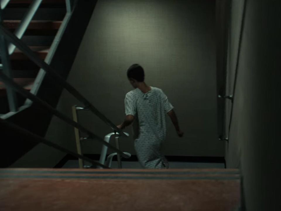 A scene from Netflix's sci-fi series "Stranger Things," showing a girl running down stairs.