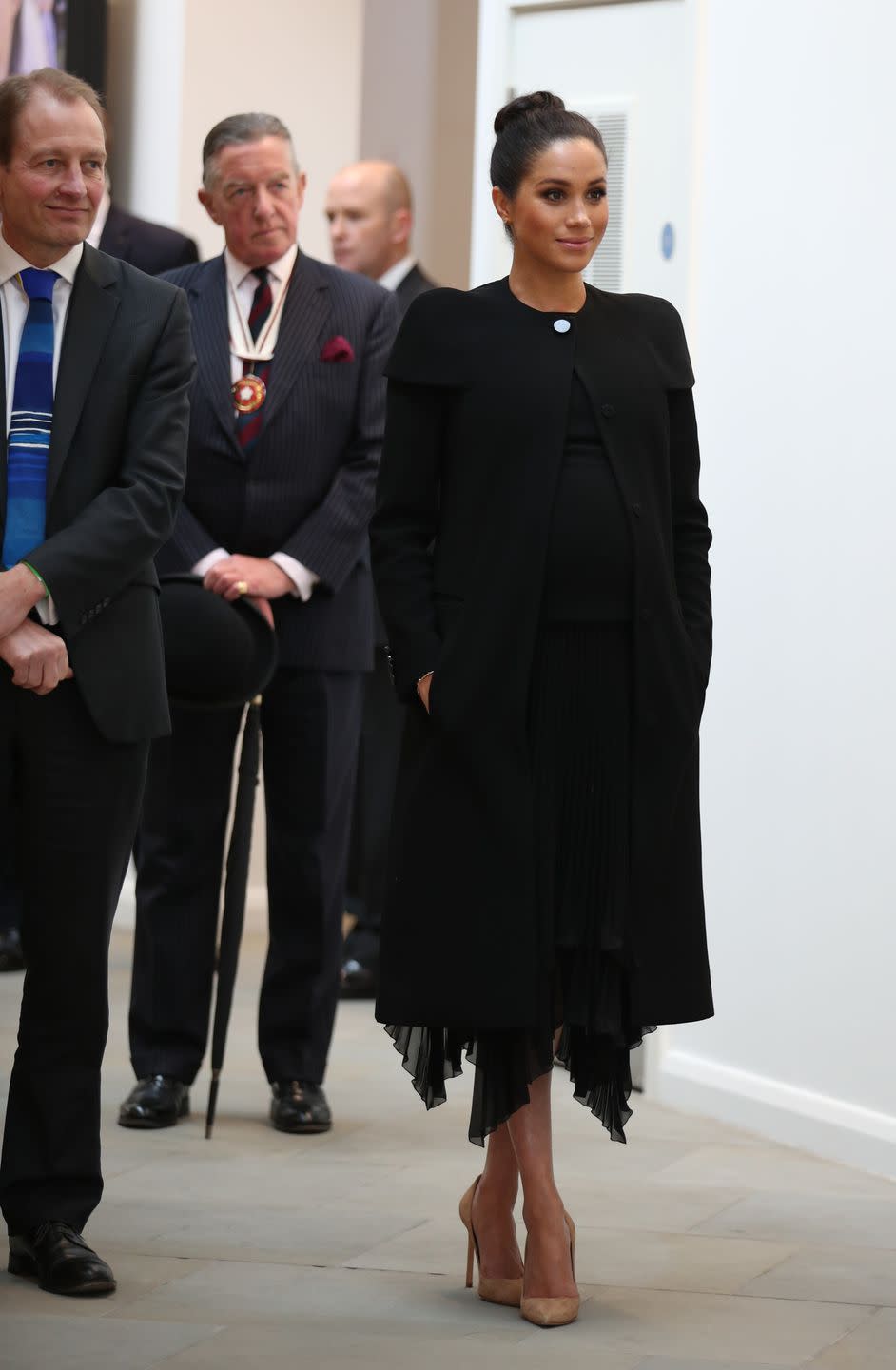 <p>Meghan looked chic in a black Givenchy coat, which she previously wore for the Remembrance Day Service in November, while visiting the Association of Commonwealth Universities. The Duchess completed the look with a black pleated chiffon dress and nude pumps. </p>