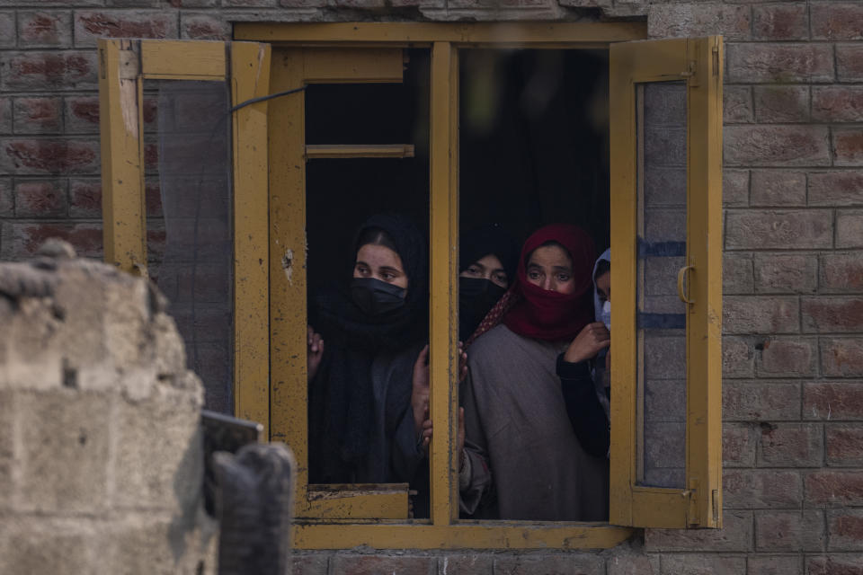 Kashmiri villagers look out from the window of a damaged residential house where suspected rebels had taken refuge, after a gunfight in Kulgam south of Srinagar, Indian controlled Kashmir, Friday, Nov. 17, 2023. Police in Indian-controlled Kashmir said government forces killed five suspected militants in a gunbattle on Thursday. (AP Photo/Dar Yasin)