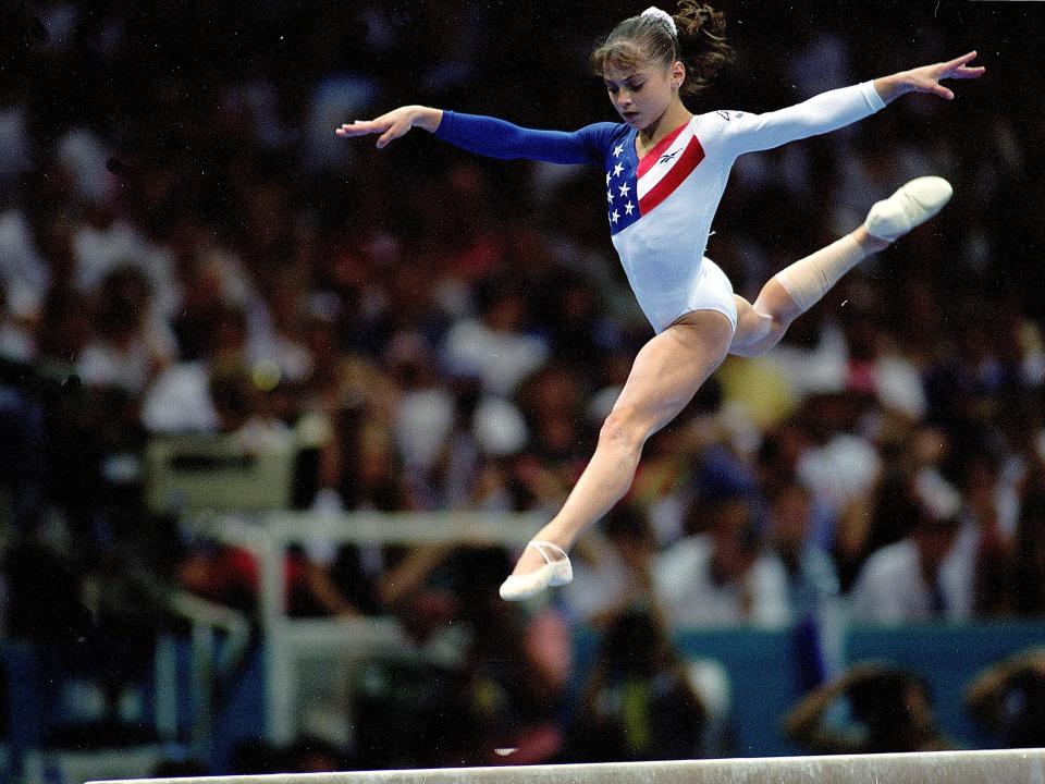 Dominique Moceanu jumps on the balance beam