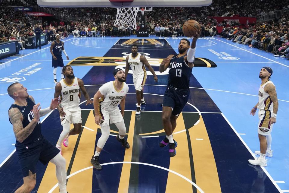 Clippers forward Paul George scores against the Pelicans during a game.