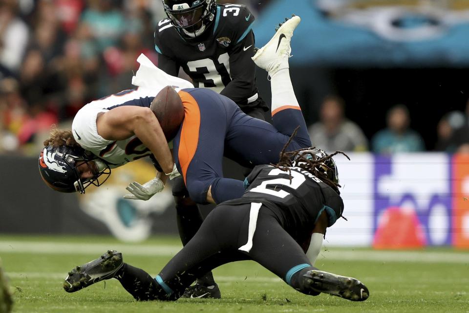 Denver Broncos tight end Greg Dulcich (80) is tackled by Jacksonville Jaguars safety Rayshawn Jenkins (2) during the NFL football game between Denver Broncos and Jacksonville Jaguars at Wembley Stadium in London, Sunday, Oct. 30, 2022. (AP Photo/Ian Walton)