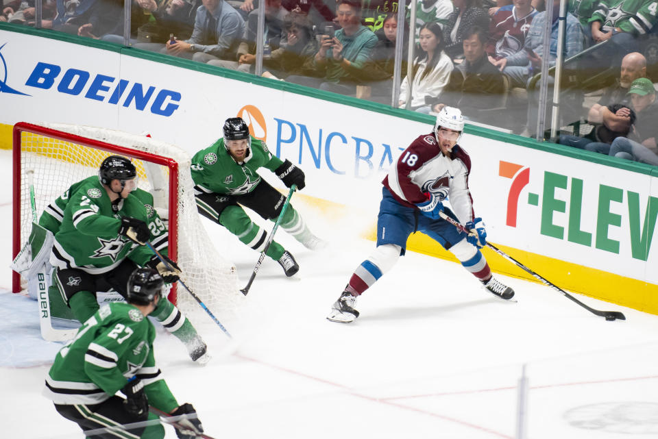 Colorado Avalanche center Alex Newhook (18) looks for an open teammate as Dallas Stars defenseman Jani Hakanpaa (2) attempts to stop him during the first period of an NHL hockey game, Saturday, March 4, 2023, in Dallas. (AP Photo/Emil T. Lippe)