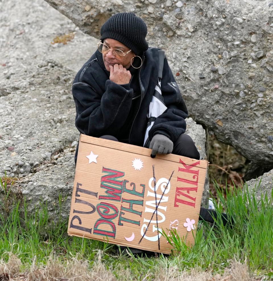 Michelle Flagg of Milwaukee rests with her anti-guns sign after marching with others during the Youth Victory Over Violence Walk along North King Drive in Milwaukee on Sunday.