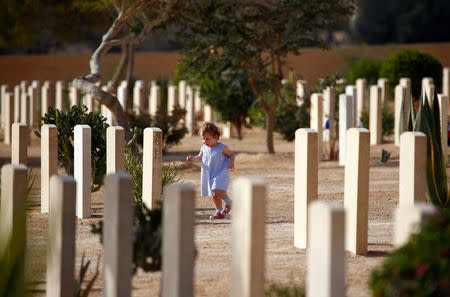 A girl runs around graves of World War Two soldiers as her family attends a ceremony for the anniversary of the Battle of El Alamein, at El Alamein war cemetery in Egypt, October 20, 2018. REUTERS/Amr Abdallah Dalsh
