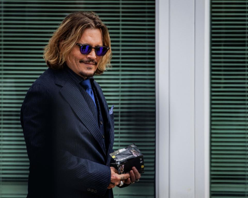 Johnny Depp smiles as he leaves the Fairfax County courthouse on 13 April (AFP via Getty Images)