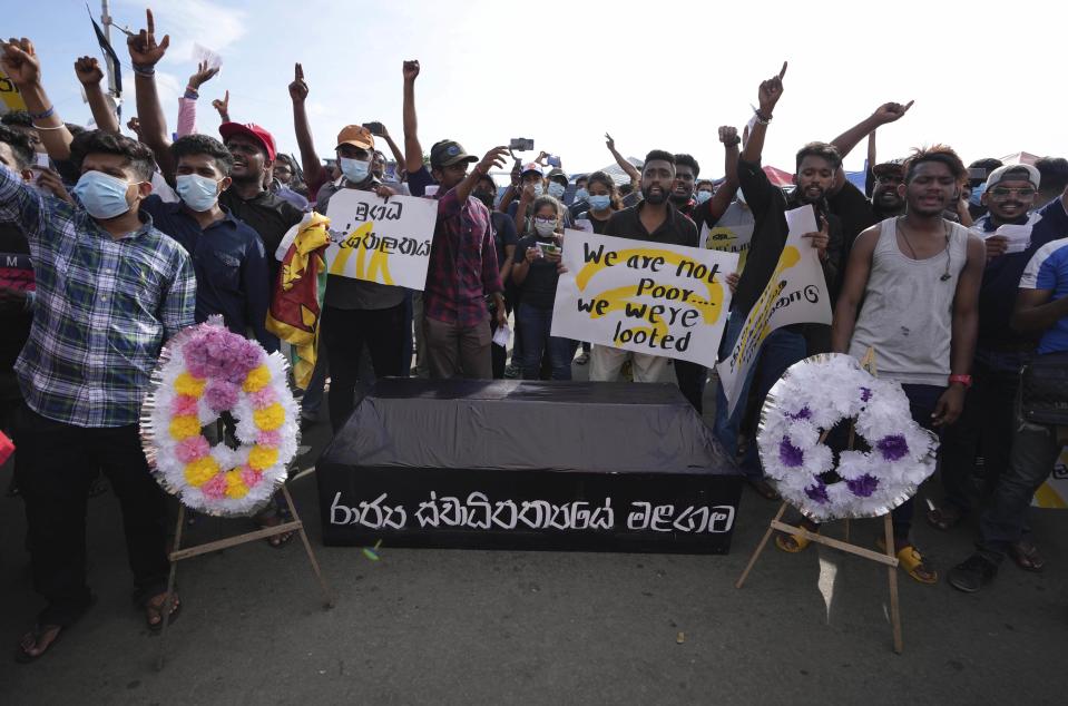 Sri Lankans protest keeping a coffin with a slogan in Sinhalese that reads " the death of state sovereignty" during an ongoing protest outside president's office in Colombo, Sri Lanka, Saturday, April 23, 2022. Thousands of Sri Lankans have protested outside President Gotabaya Rajapaksa’s office in recent weeks, demanding that he and his brother, Mahinda, who is prime minister, quit for leading the island into its worst economic crisis since independence from Britain in 1948. (AP Photo/Eranga Jayawardena)