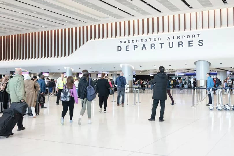 Passengers waiting at Manchester Airport departures