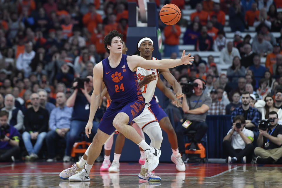 Clemson center PJ Hall (24) reaches for the ball in front of Syracuse forward Maliq Brown during the second half of an NCAA college basketball game in Syracuse, N.Y., Saturday, Feb. 10, 2024. (AP Photo/Adrian Kraus)