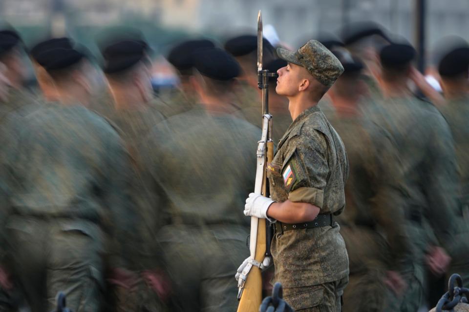 Marines march past a honour guard soldier during a Naval parade rehearsal in St. Petersburg, Russia, Tuesday, July 19, 2022.