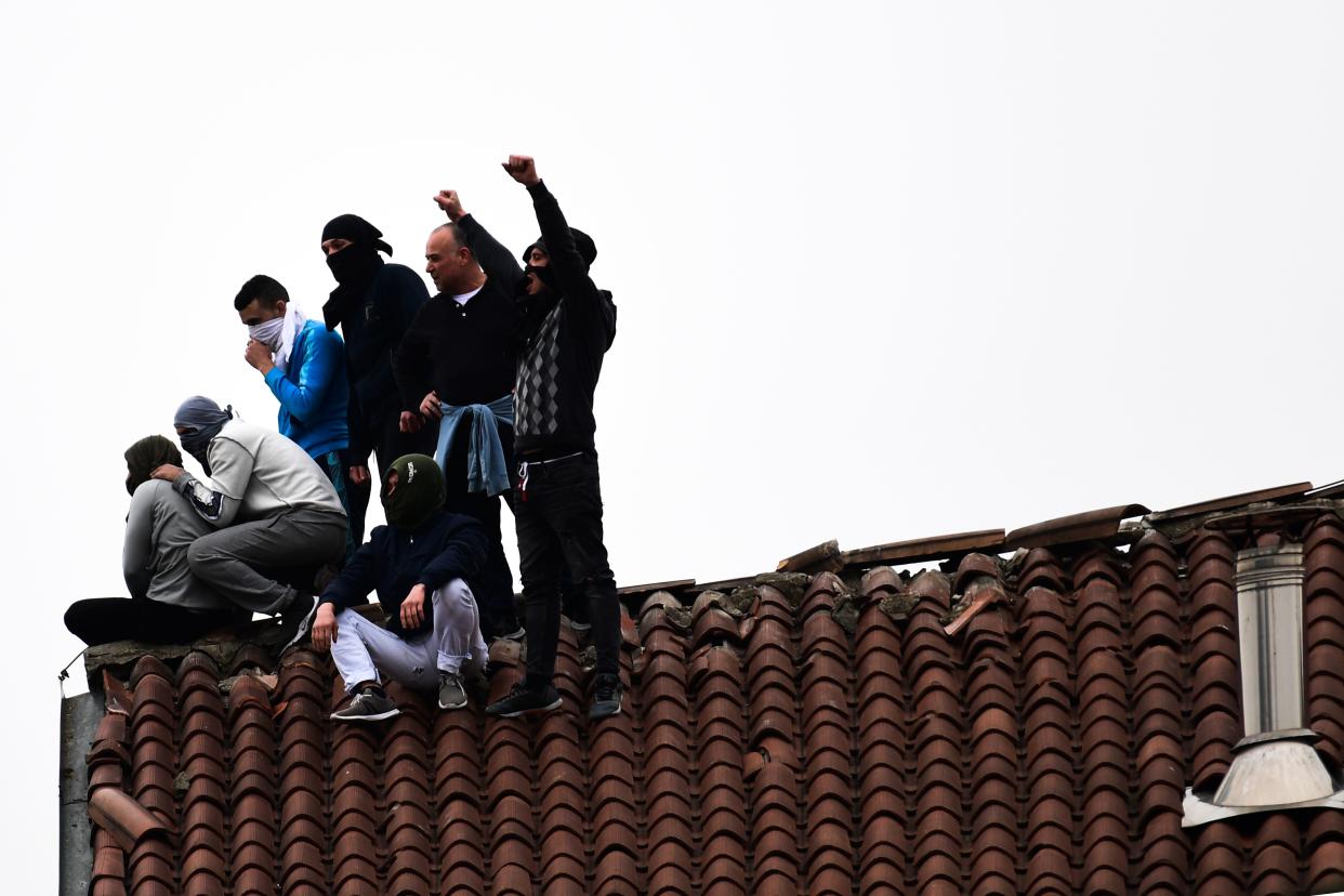 Inmates stage a protest on a rooftop of a wing at the San Vittore prison in Milan on March 9, 2020, in one of Italy's quarantine red zones. - Inmates in four Italian prisons have revolted over new rules introduced to contain the coronavirus outbreak, leaving one prisoner dead and others injured, a prison rights group said on March 8. Prisoners at jails in Naples Poggioreale in the south, Modena in the north, Frosinone in central Italy and at Alexandria in the northwest had all revolted over measures including a ban on family visits, unions said. (Photo by Miguel MEDINA / AFP) (Photo by MIGUEL MEDINA/AFP via Getty Images)