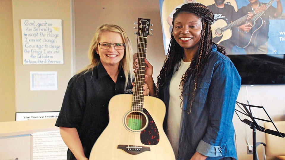 Angela receiving graduation guitar