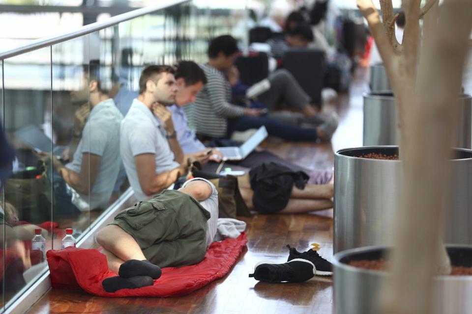 People wait inside the Munich Airport in Munich, Germany, Tuesday, Aug. 27, 2019. Munich Airport says it has closed some of its terminals because a person has likely entered the "clean area" through an emergency exit door. The international airport tweeted Tuesday morning that terminal 2 and areas B and C or terminal 1 had been closed for police operations.(AP Photo/Matthias Schrader)