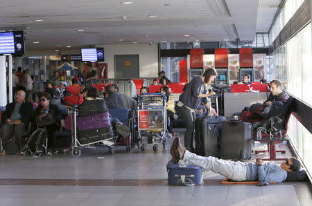 Passengers rest and wait for their flights at the departure area inside the international airport of Santiago, Chile December 17, 2015. REUTERS/Carlos Vera