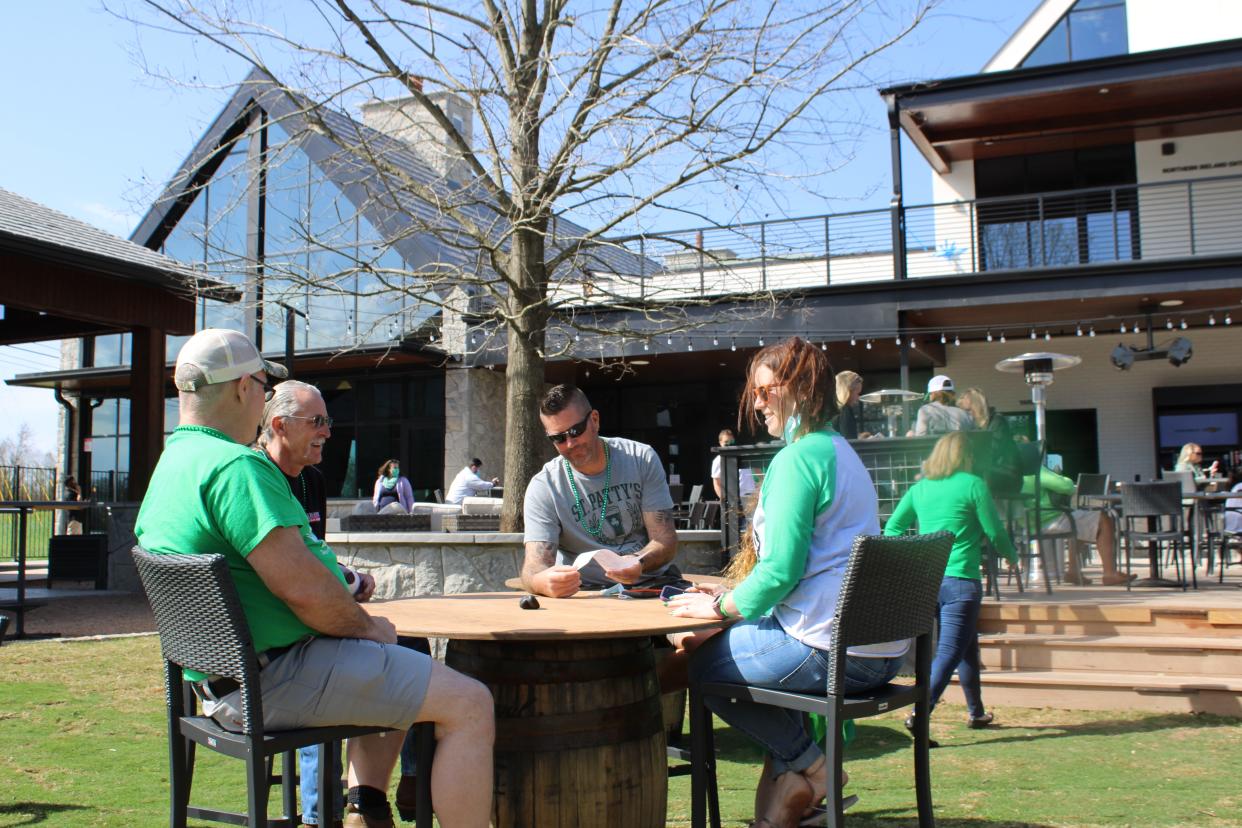 Guests sit outside at Cork & Barrel's patio for its grand opening on March 17, 2021 to celebrate St. Patrick's Day in Round Rock. The pub features feature a chef’s counter, Irish snugs, a wine room, indoor and outdoor stages, and a nearly acre-wide beer garden.