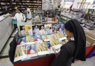 A nun views a picture of the late Pope John Paul II inside a religious store in Tayuman, metro Manila April 14, 2014. REUTERS/Romeo Ranoco