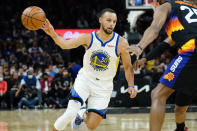 Golden State Warriors guard Stephen Curry (30) dishes off against the Phoenix Suns during the first half of an NBA basketball game, Tuesday, Nov. 30, 2021, in Phoenix. (AP Photo/Matt York)