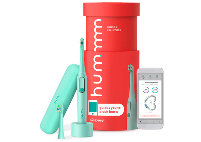 Teal electric toothbrush on charger with backup head shown with coral cylinder packaging and smartphone nearby to illustrate the app capabilities
