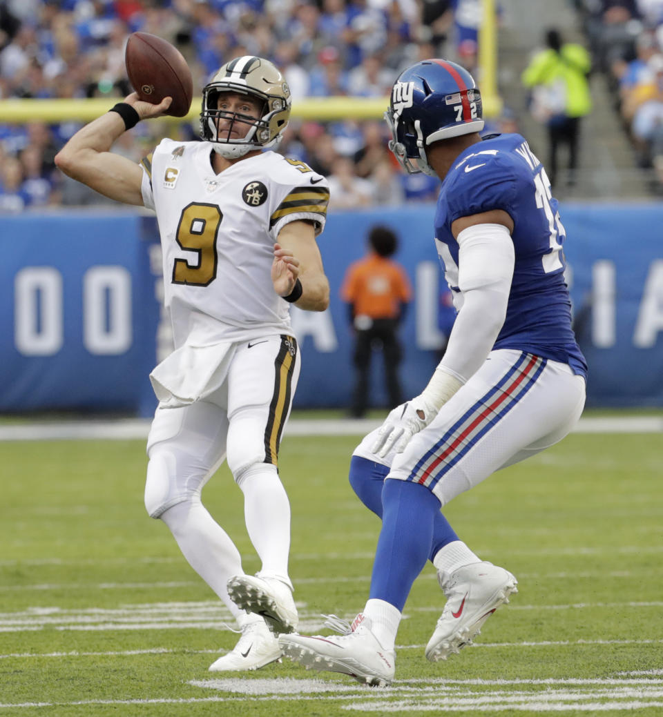 New Orleans Saints quarterback Drew Brees, left, looks to throw past New York Giants' Kerry Wynn during the first half of an NFL football game, Sunday, Sept. 30, 2018, in East Rutherford, N.J. (AP Photo/Julio Cortez)