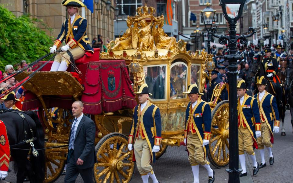 King Willem-Alexander and his wife Queen Maxima arrive in the Golden Carriage at Noordeinde Palace in 2013.  - AP