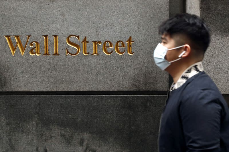 FILE PHOTO: A man wears a protective mask as he walks on Wall Street during the coronavirus outbreak in New York