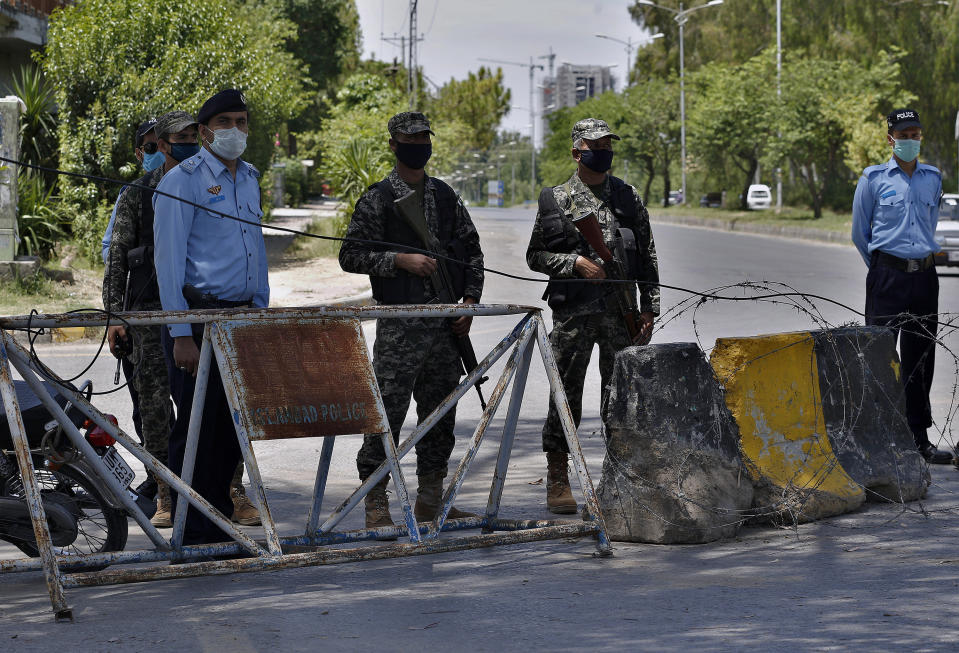 Pakistan paramilitary soldiers and a police officers stand guard at a checkpoint of a restricted area to help to contain the spread of new coronavirus, in Islamabad, Pakistan, Saturday, June 13, 2020. Capital administration sealed few areas of Islamabad following the decision taken on the advice of the Health Department and epidemiologists after hundreds of cases were reported from these areas. (AP Photo/Anjum Naveed)