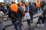 Demonstrators hold orange balloons at a rally in solidarity with Kfir Bibas, an Israeli boy who spent his first birthday Thursday in Hamas captivity in the Gaza Strip, in Tel Aviv, Israel, Thursday, Jan. 18, 2024. The plight of Bibas, the youngest hostage held by Hamas, has captured the nation's attention and drawn attention to the government's failure to bring home more than 100 hostages still held by Hamas after more than three months of war. (AP Photo/Oded Balilty)