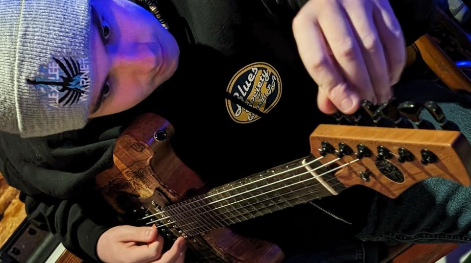 Alex Lee Warner tunes his guitar for his Road to Memphis Benefit Jam at The Underground Live in Camp Hill.