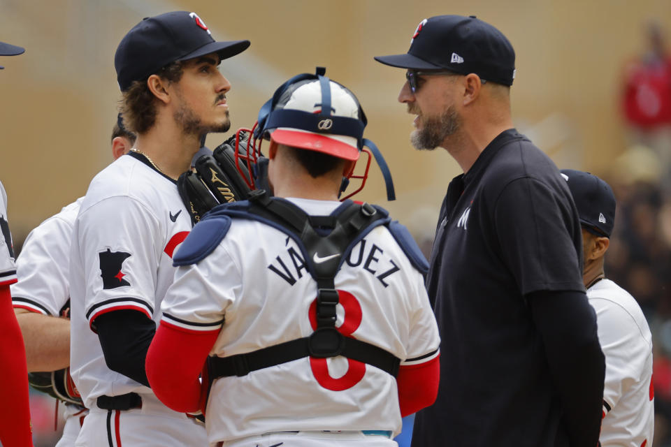 Minnesota Twins starting pitcher Joe Ryan, left, listens to manager Rocco Baldelli, right, as the latter pulls him from throwing to the New York Yankees as catcher Christian Vazquez watches in the sixth inning of a baseball game Thursday, May 16, 2024, in Minneapolis. (AP Photo/Bruce Kluckhohn)