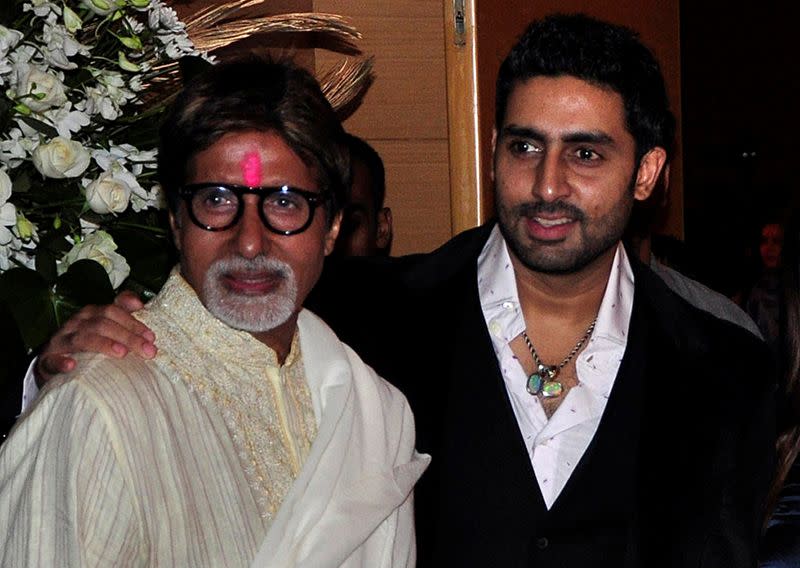 FILE PHOTO: Bollywood actors Amitabh and Abhishek Bachchan pose in Mumbai