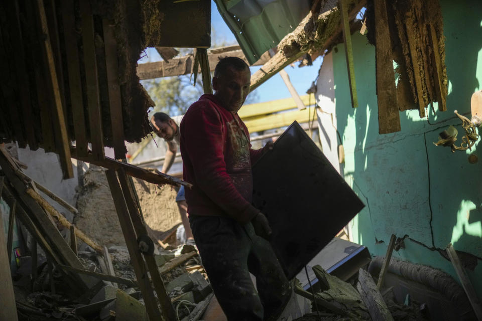 Locals remove debris from destroyed houses after a Russian rocket strike was hit by Ukraine’s anti-aircraft system in a residencial area in Zaporizhzhia, Ukraine, Thursday, April 28, 2022. The strike came as parts of southern Ukraine prepare for a further advance by Russian forces who seek to strip the country of its seacoast. (AP Photo/Francisco Seco)