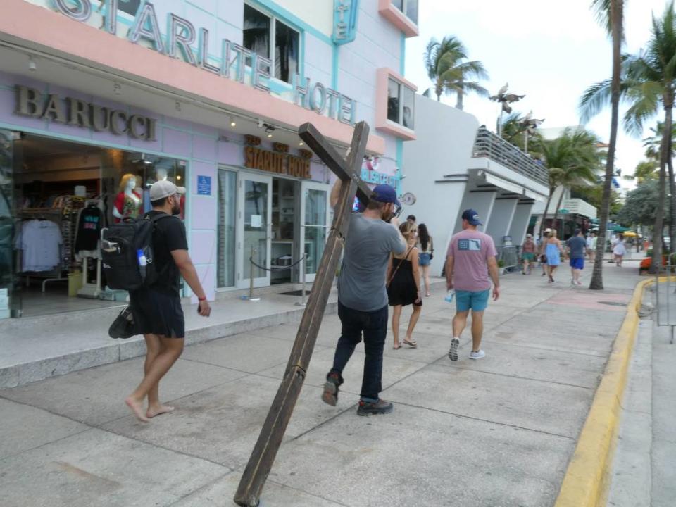 Wade Aaron, de 35 años, caminaba por Ocean Drive con una gran cruz de madera al hombro mientras visitaba Miami Beach durante las vacaciones de primavera, el domingo 10 de marzo de 2024.